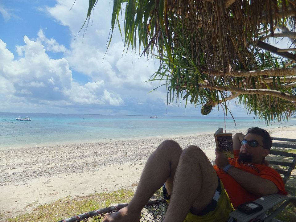 Me on a secluded beach, reading 'What to Listen for in Music' by Aaron Copland